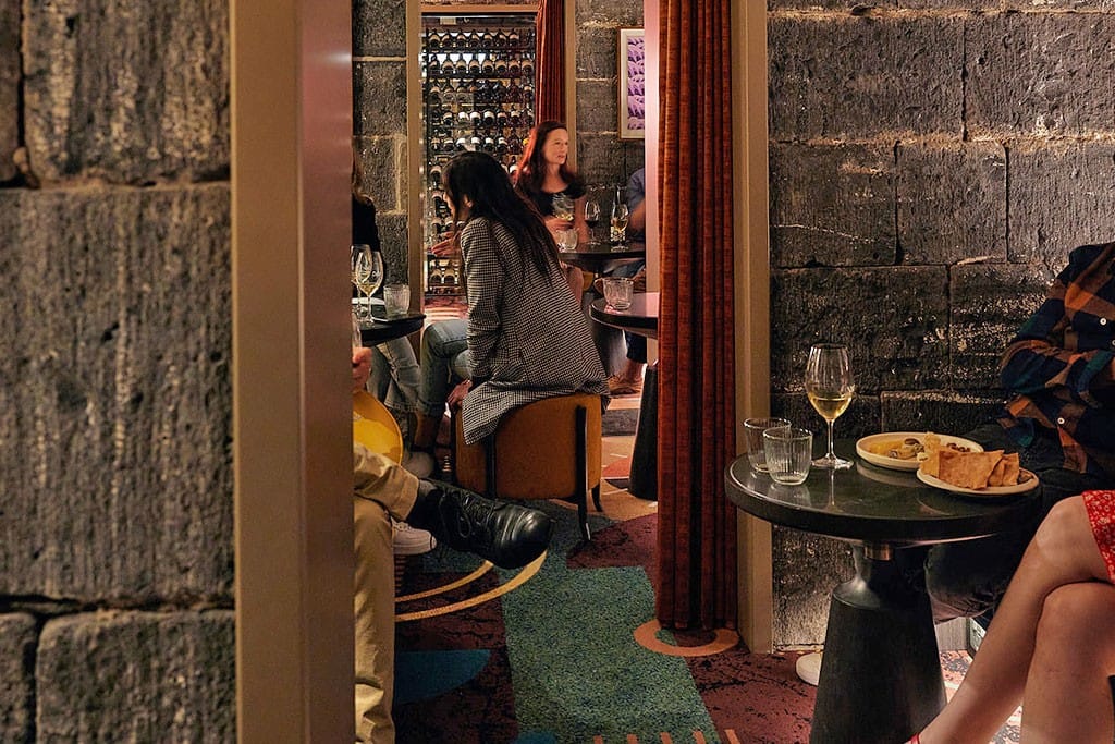 A group gathered in an Olivine booth with wine and food